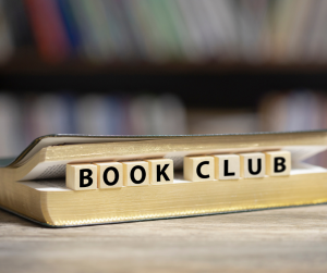 Book club written on wooden blocks inside the text block of an open book